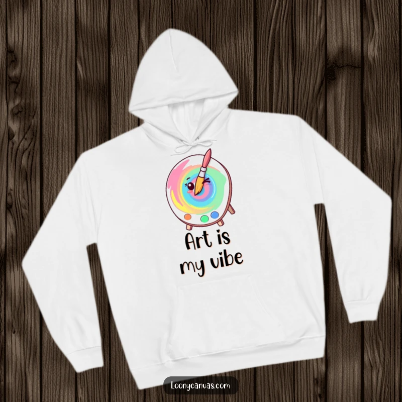 Funny kawaii winking paintbrush creating a colorful paint swirl, cozy hoodie for artists and a humorous gift option.