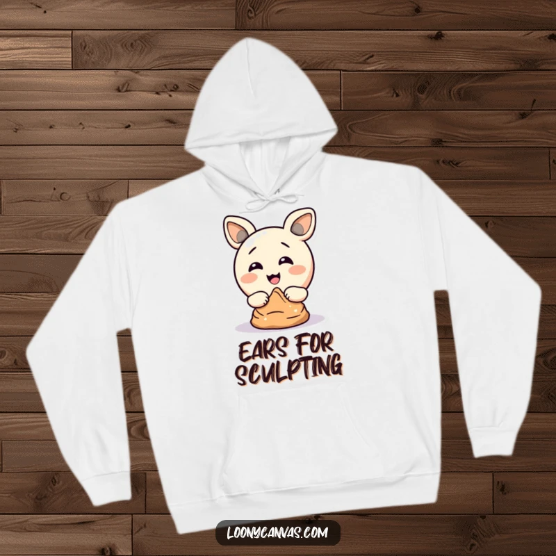 Funny hoodie showing a delighted circle character using its ears to sculpt clay, a comical and cozy representation of artistic struggle.