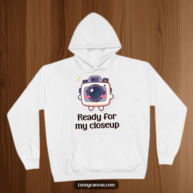 Funny kawaii camera character with a mischievous grin, printed on a soft hoodie, celebrating photography with humor.