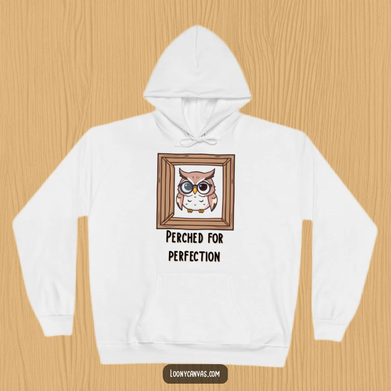 Funny hoodie depicting a determined owl with a monocle scrutinizing a crooked frame, embodying critical observation.