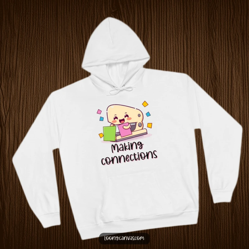 Cheerful stapler character enthusiastically joining colorful paper squares, printed on a soft hoodie.