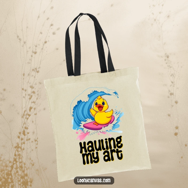 Funny kawaii excited rubber ducky surfing a vibrant paint wave on a tote bag, a functional and humorous art gift.
